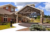 Exterior view of RiverMead entrance with a covered driveway, brick facade, and landscaped approach.