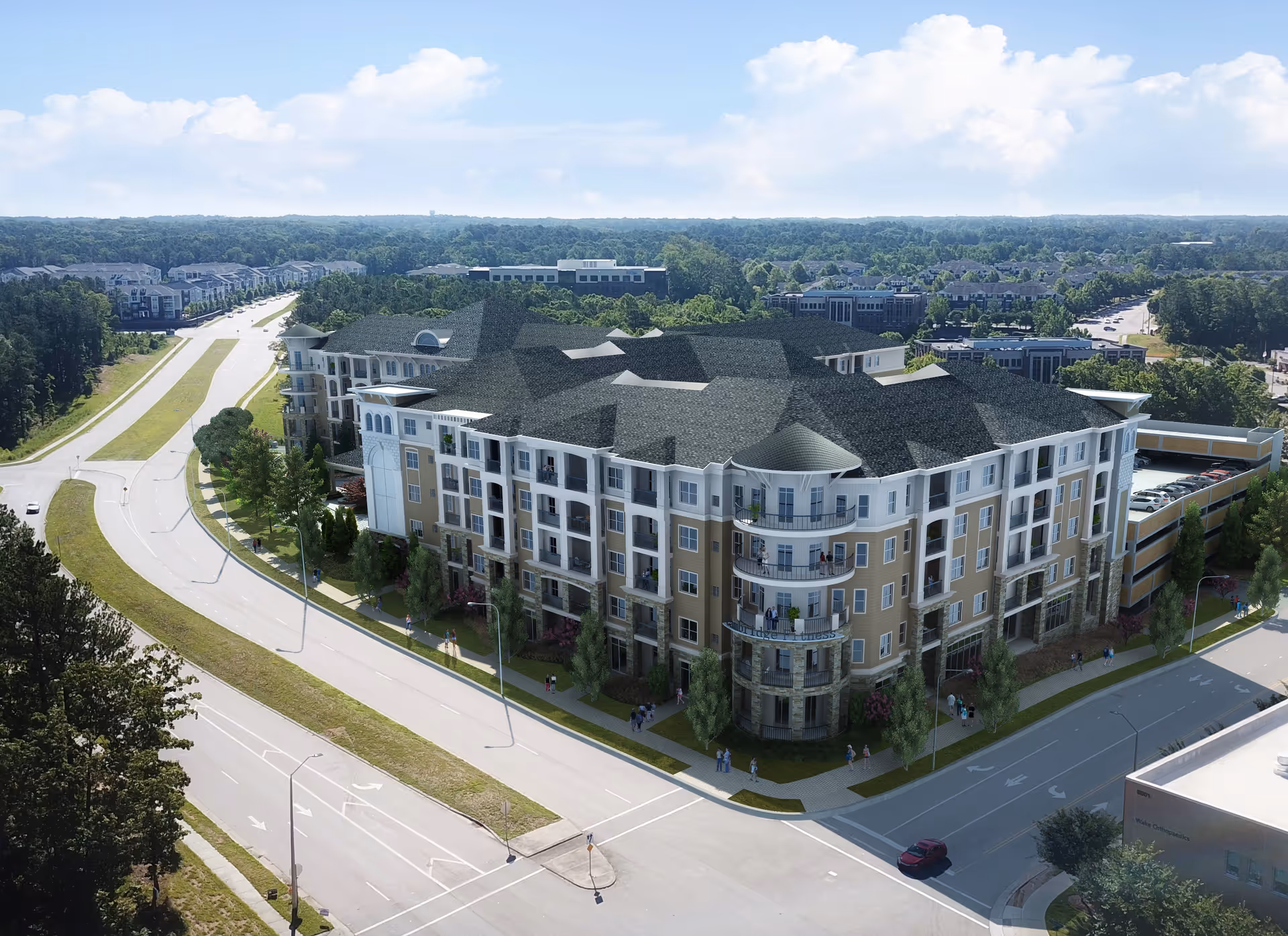 Aerial view of a large multi-story residential building with balconies, surrounded by roads and greenery under a partly cloudy sky.
