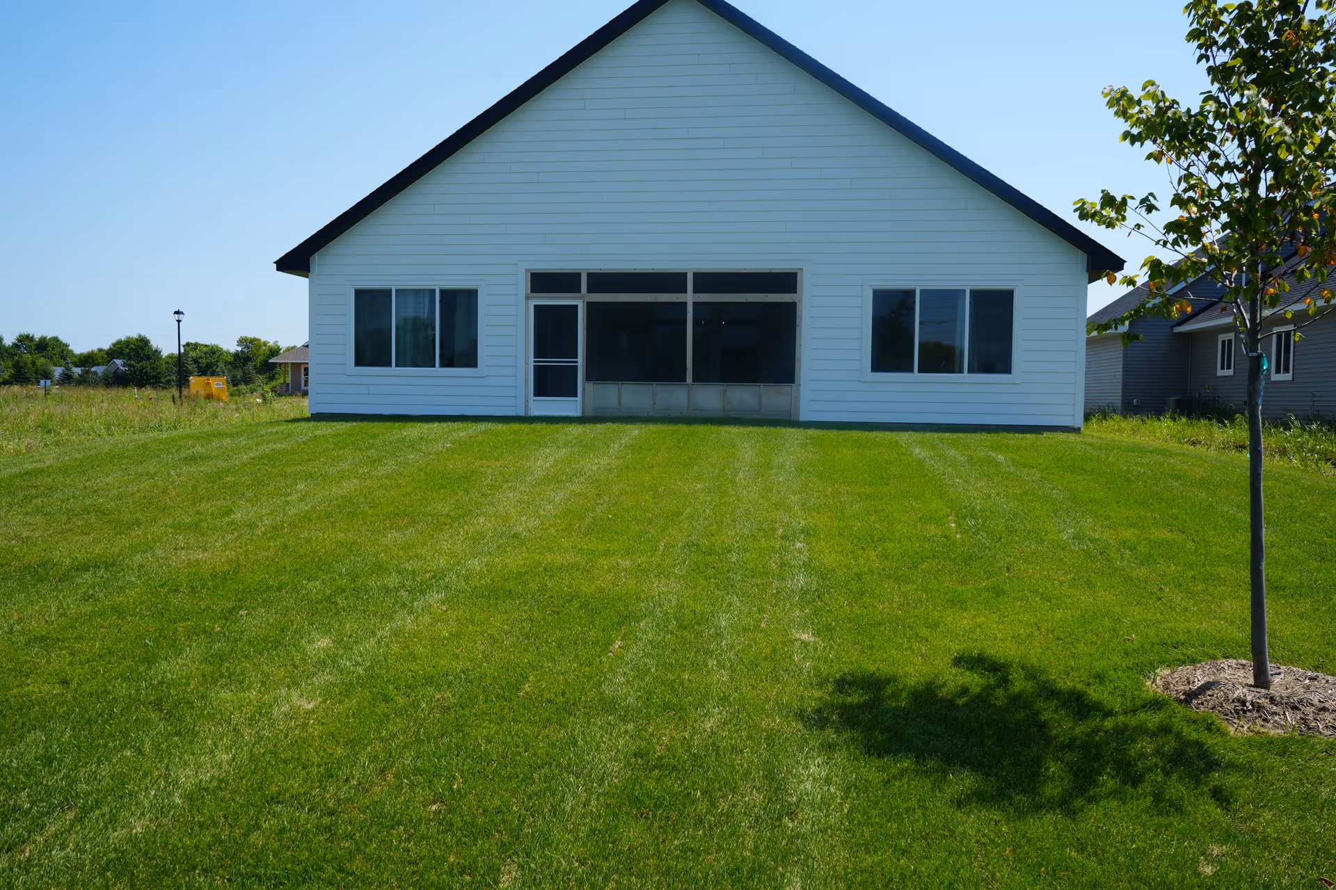 White, single-story building with large front windows and a green lawn.