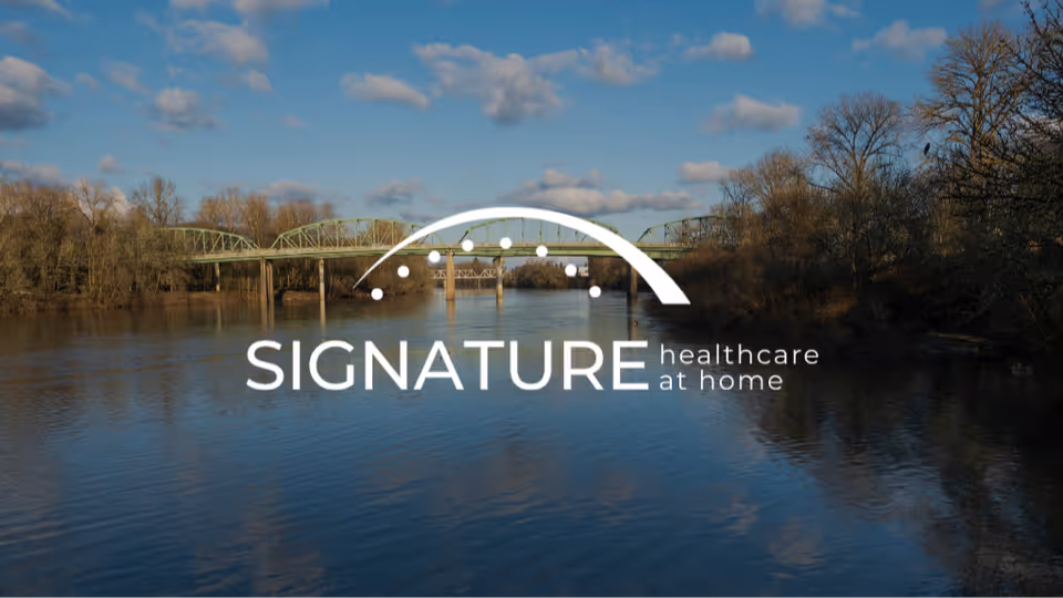 River scene with a bridge and trees, featuring the Signature Healthcare at Home logo.