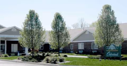 Oakwood Health Campus exterior with manicured lawn, trees, and sign.
