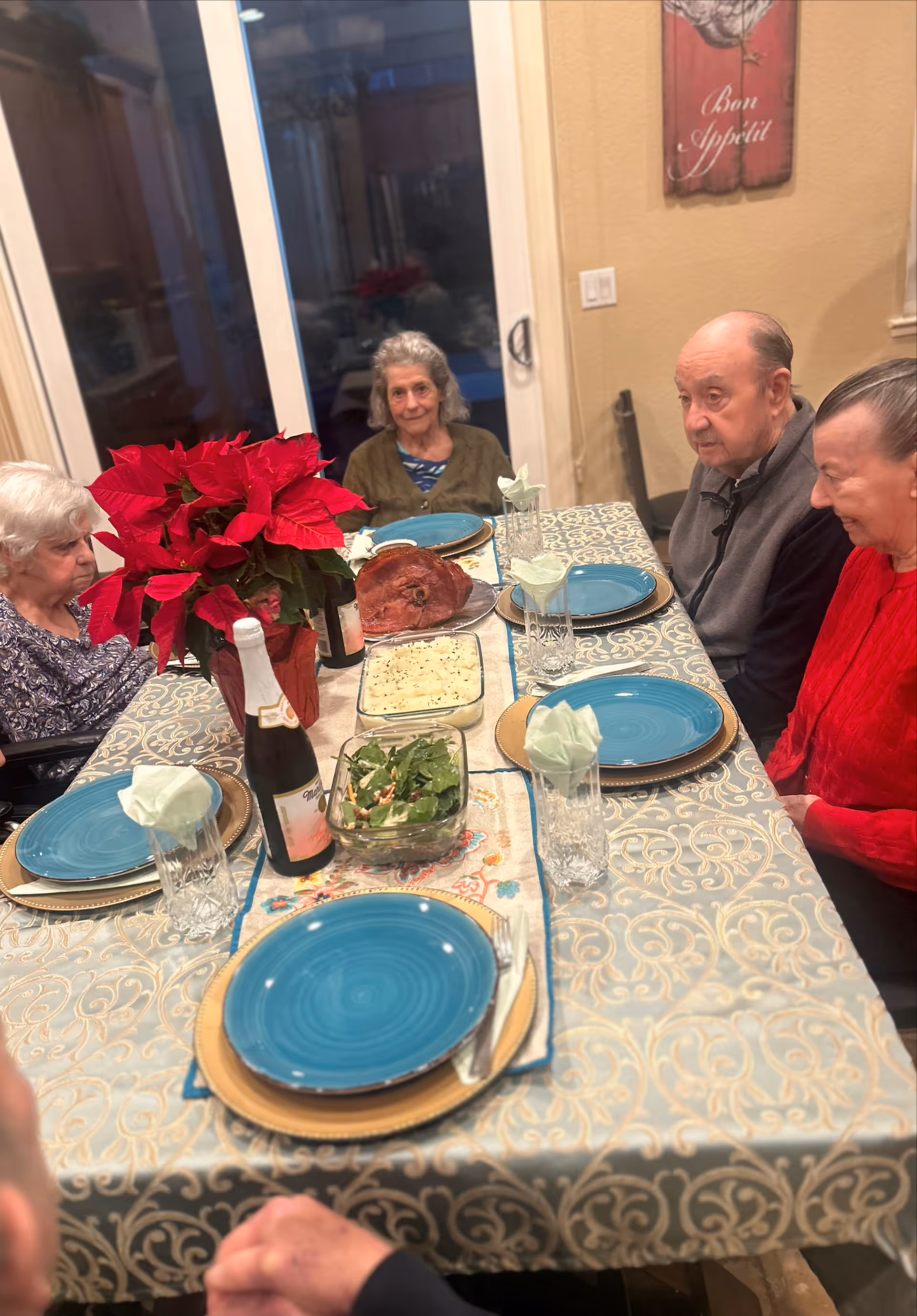 Group of seniors seated around a decorated dining table with food and drinks.