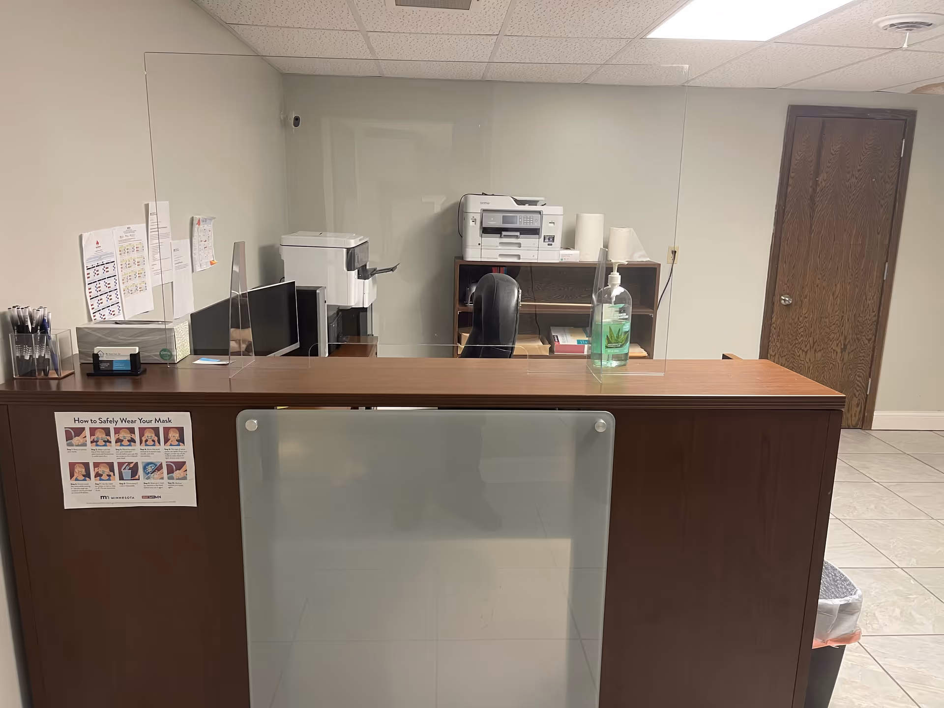 My Home Care, Inc. reception desk with glass partition and printers.