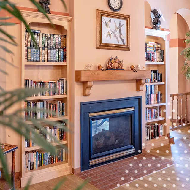 Cozy living area with a fireplace, built-in bookshelves, and a mantel.