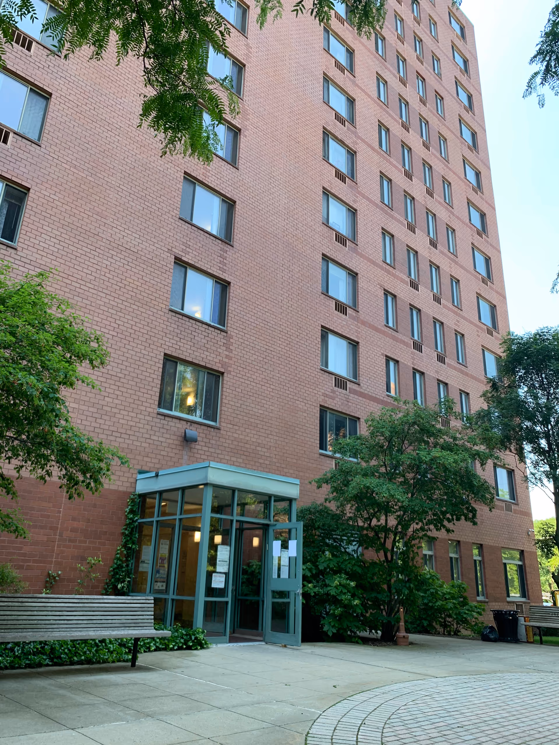 Exterior view of Council Tower II, a brick senior living building with glass entrance.