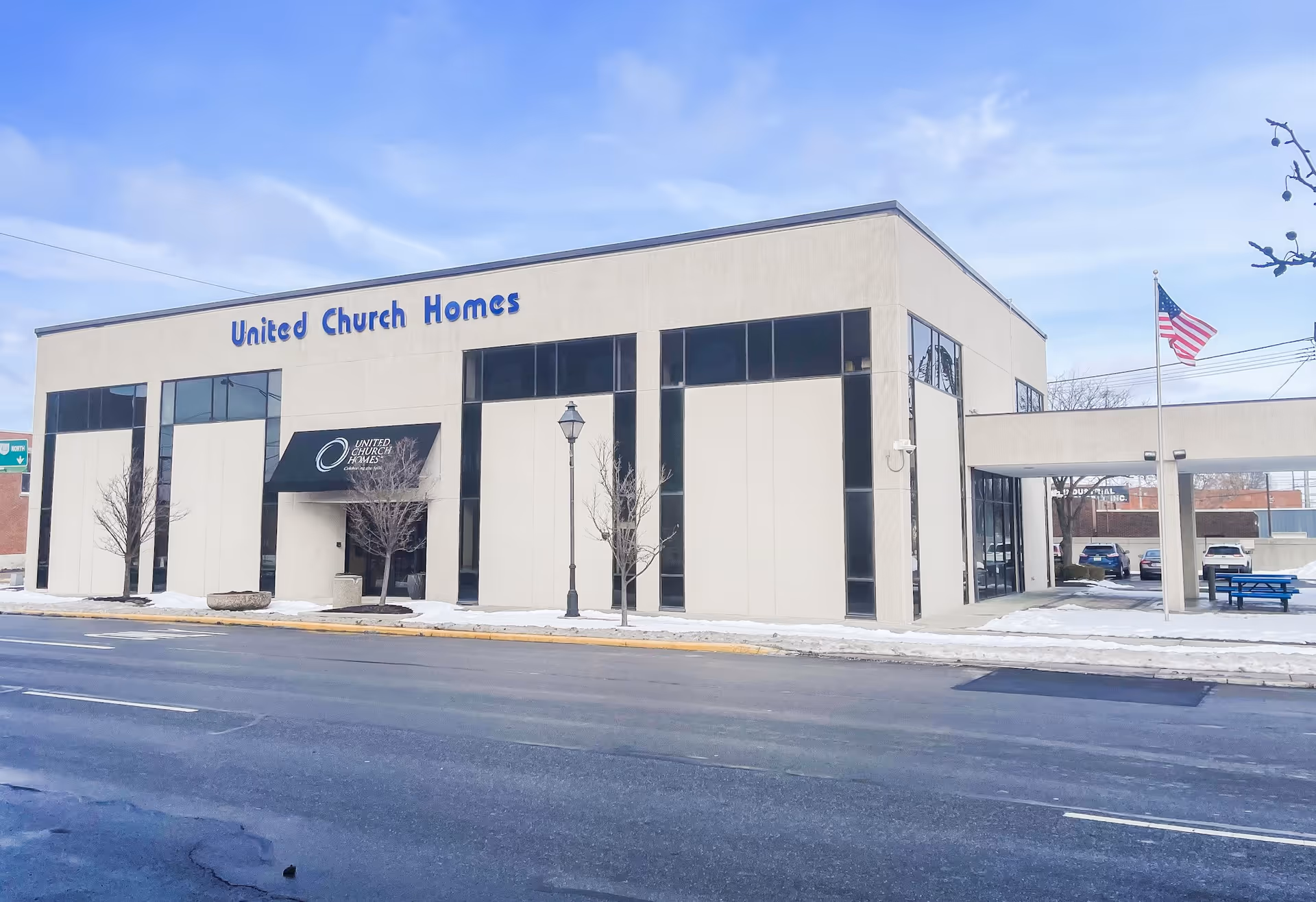 Exterior view of a United Church Homes facility with a modern beige facade and blue signage.