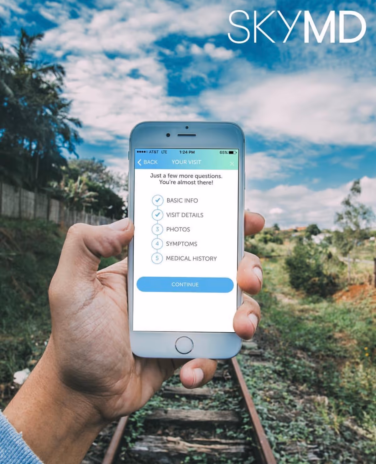 Hand holds smartphone displaying SkyMD app against a blue sky and greenery.