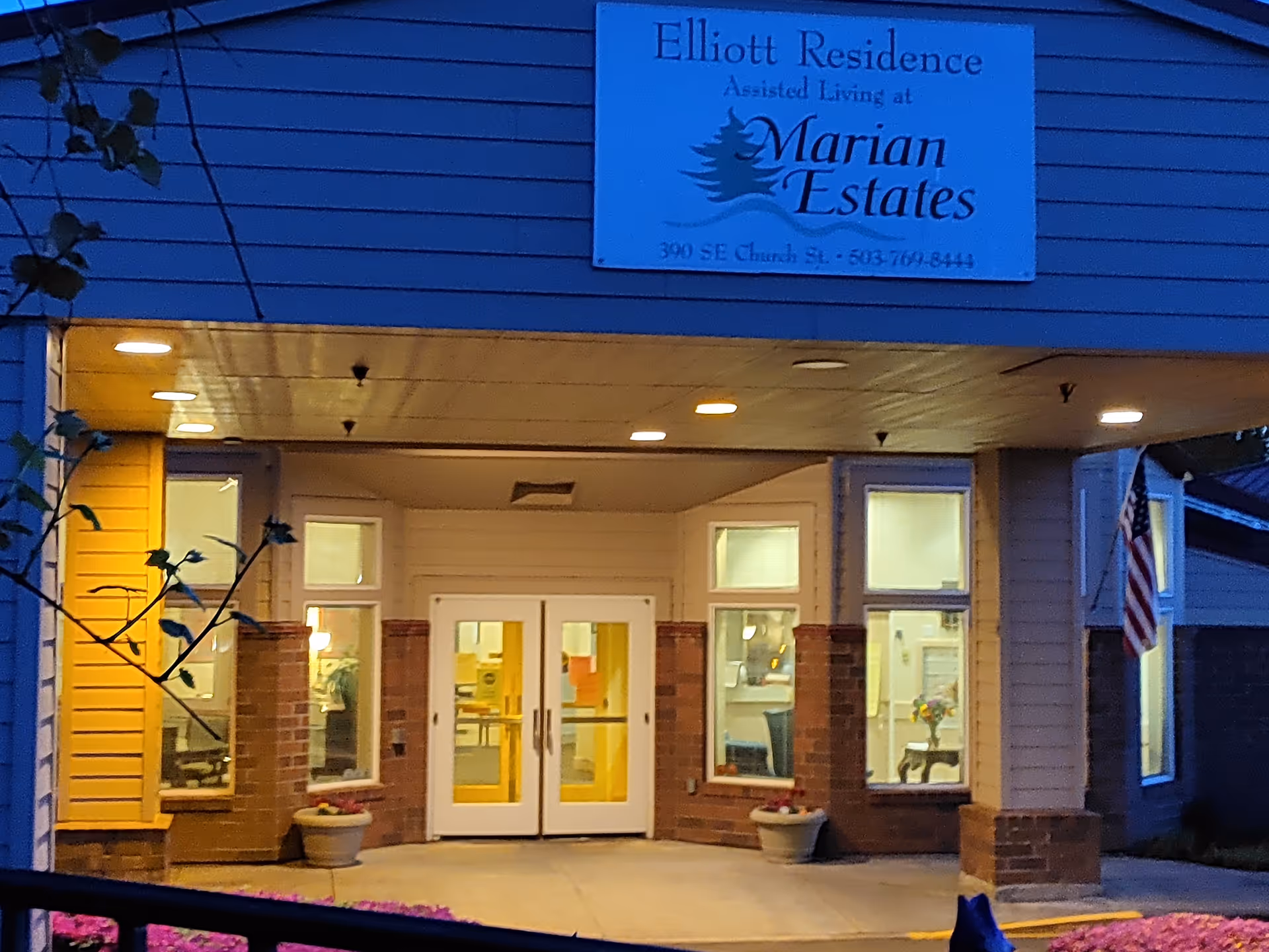 Exterior view of Elliott Residence entrance with double doors and lit windows.