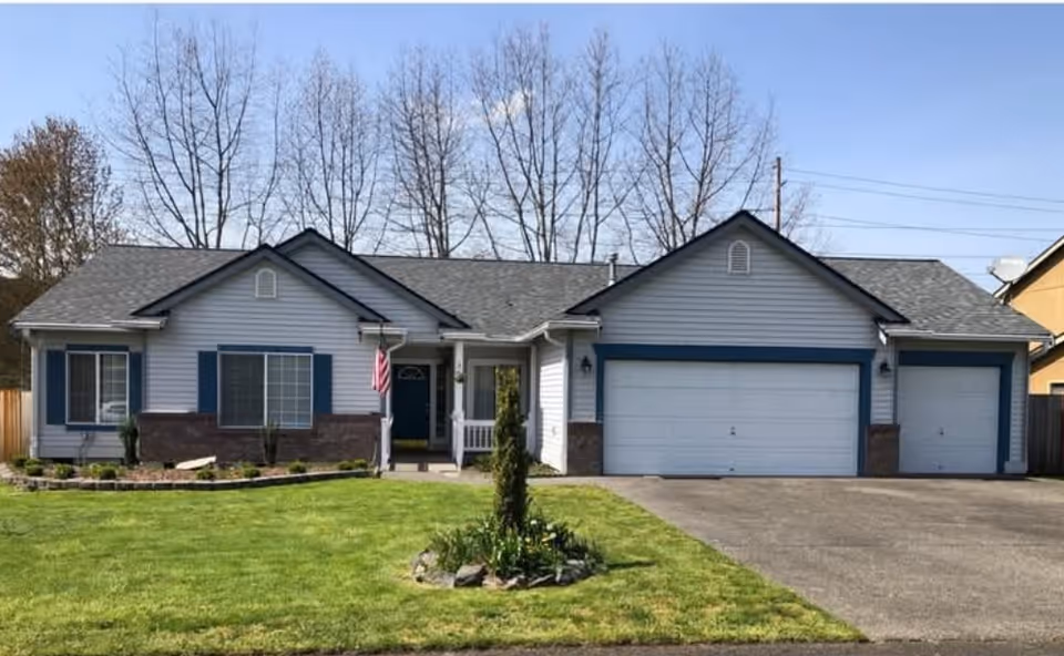 A single-story residential-style senior facility with manicured lawn and a two-car garage.