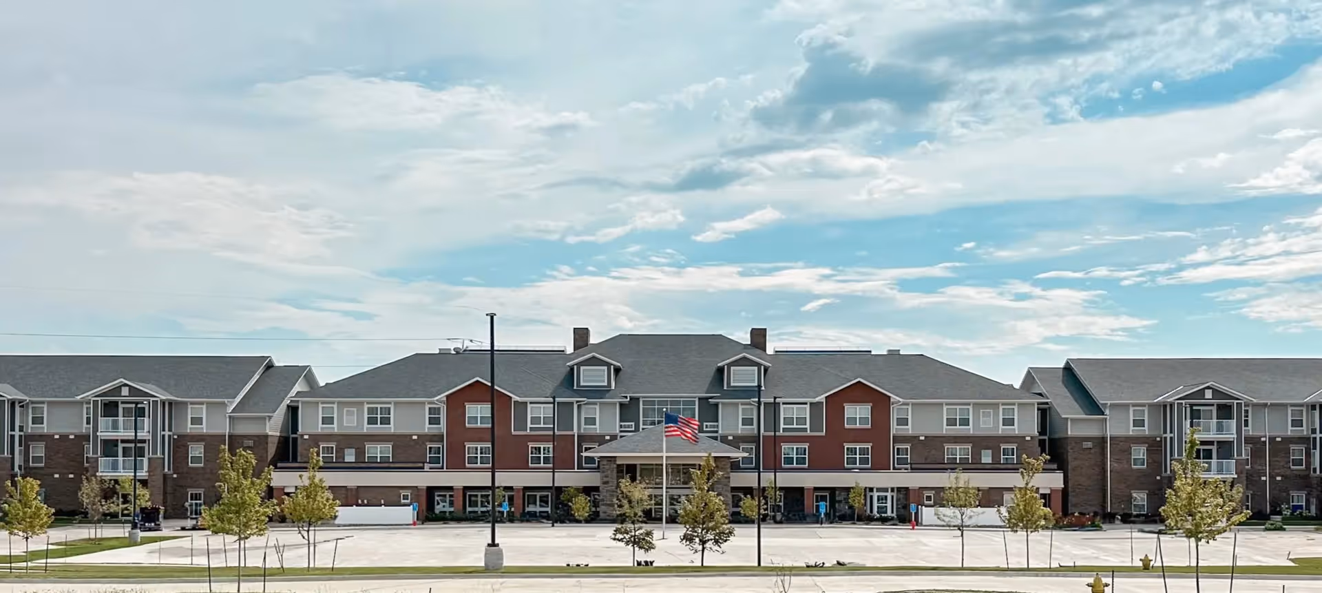 Exterior view of Glen Meadows senior living facility with brick facade and a parking lot.