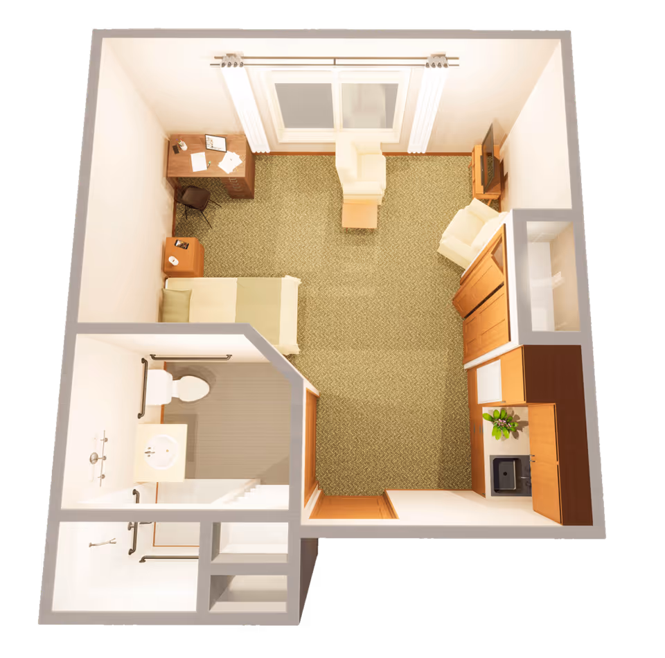 Top-down view of a small assisted living apartment featuring a bedroom area with a single bed, nightstand, and desk with chair. The living area includes two armchairs, a small table, and a TV on a stand. There is a kitchenette with cabinets, a sink, and a small counter. The bathroom has a toilet, sink, and a walk-in shower with grab bars.