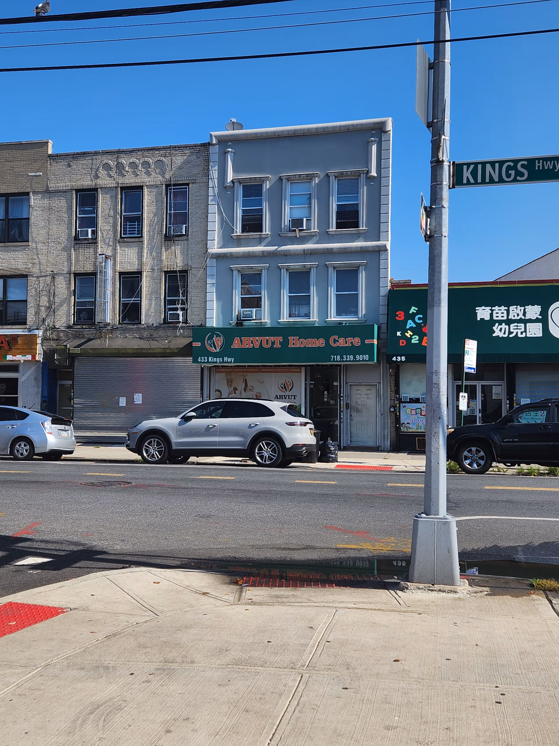 Exterior view of ARVUT Home Care storefront on a city street with parked cars.