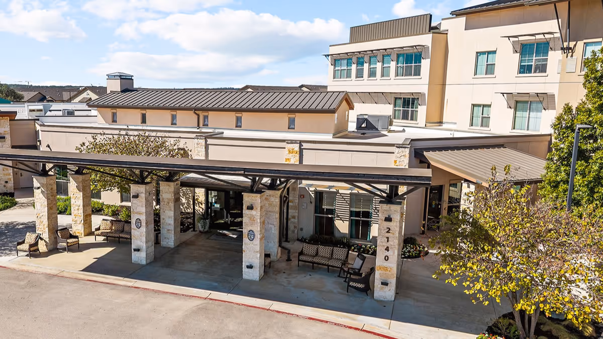Exterior view of Élan Westpointe at New Braunfels entrance with benches and canopy.