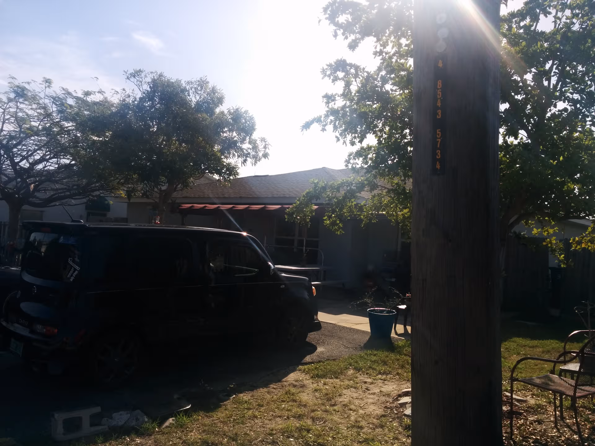 Exterior view of Wilson Place with a parked van, trees, and outdoor seating