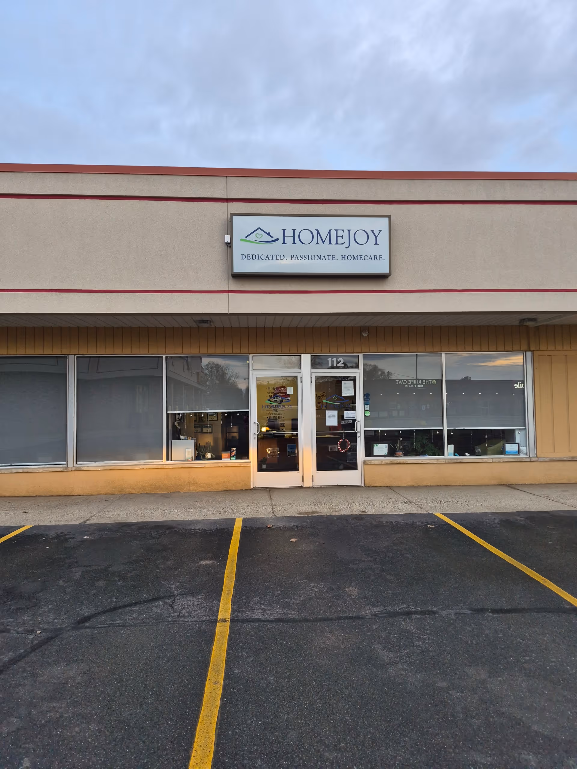 Exterior of HomeJoy of Marshall building with sign and glass entrance doors.
