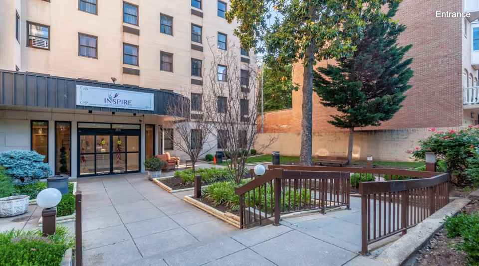 Exterior entrance and landscaped courtyard of Inspire Rehabilitation & Health Center showing the building facade, walkway and ramp.