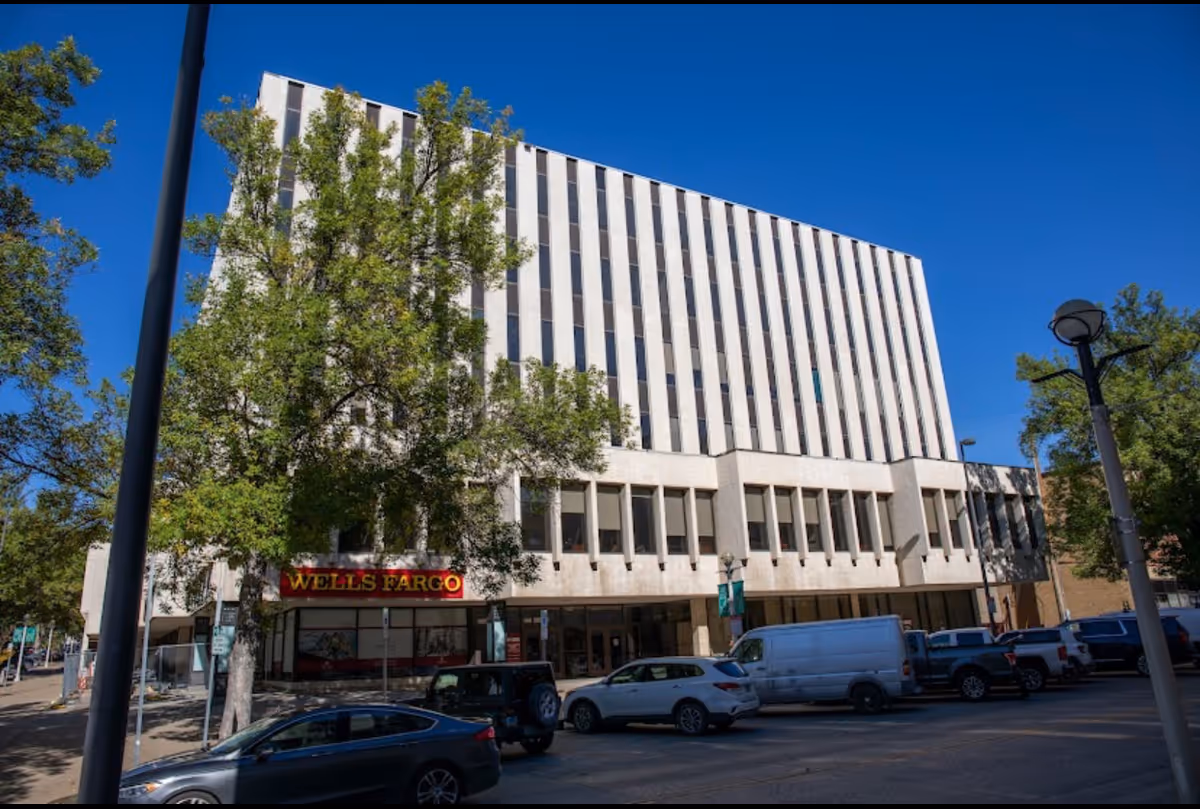 Tall beige building with a Wells Fargo storefront on a busy city street.