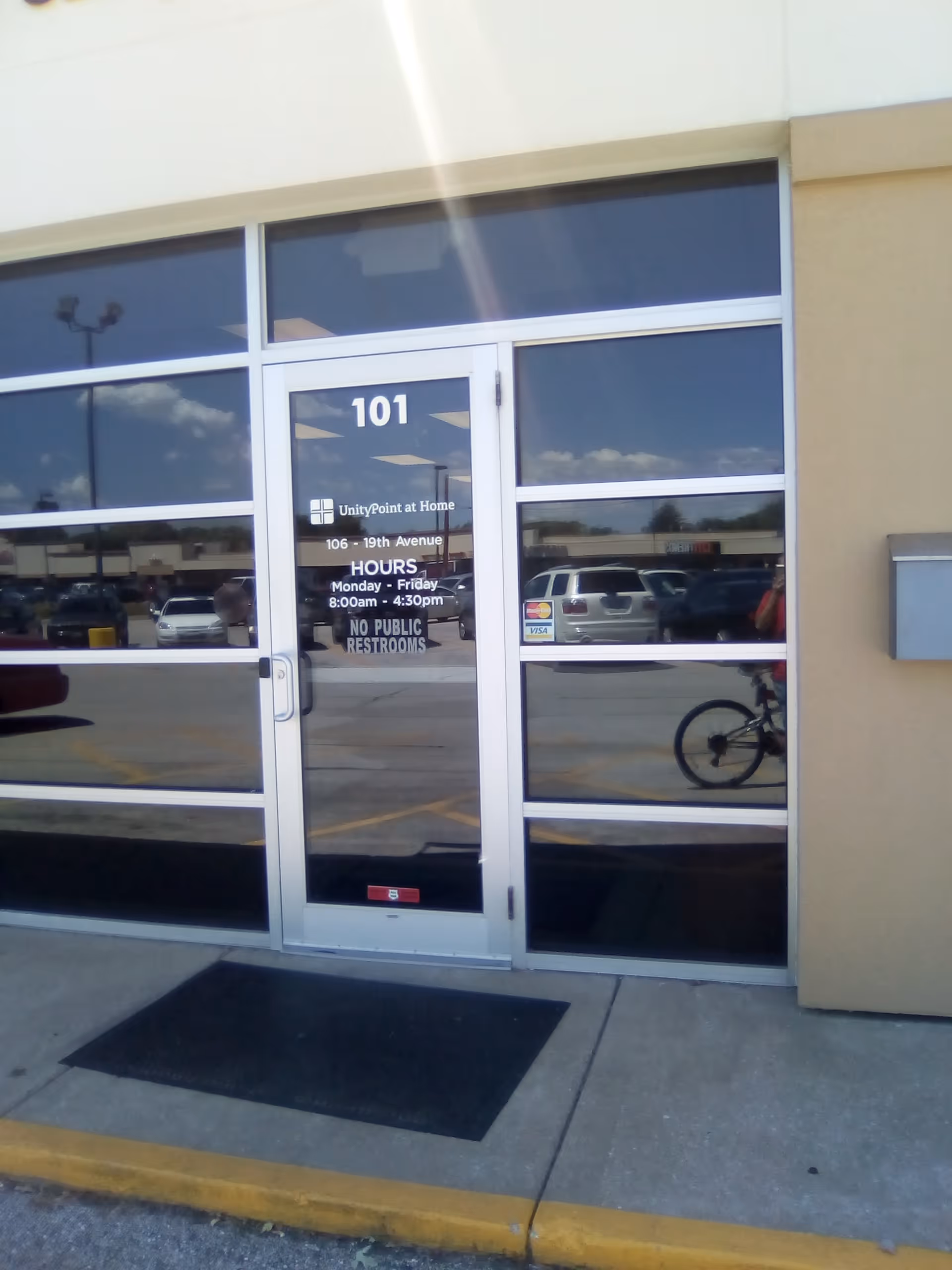 Exterior glass entrance door labeled 101 with parking lot reflections.
