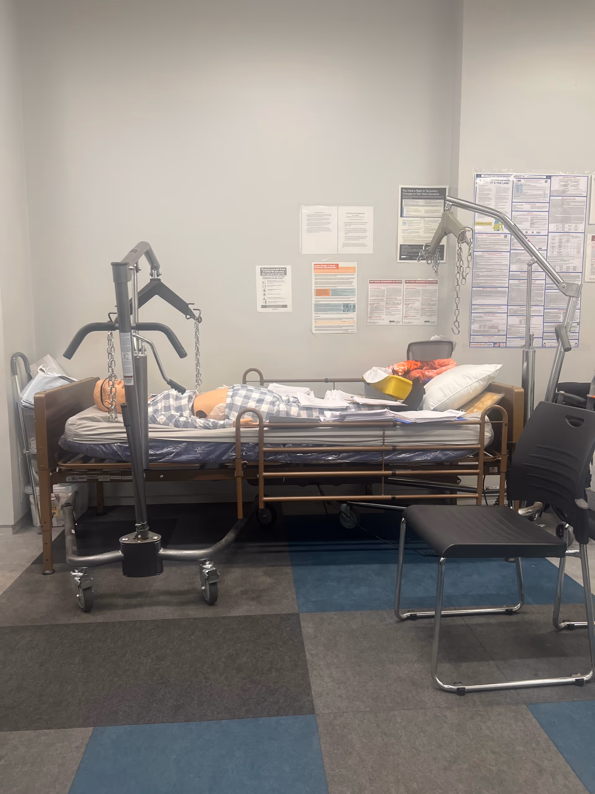 Hospital-style bed with patient lift equipment in a clinical interior room.