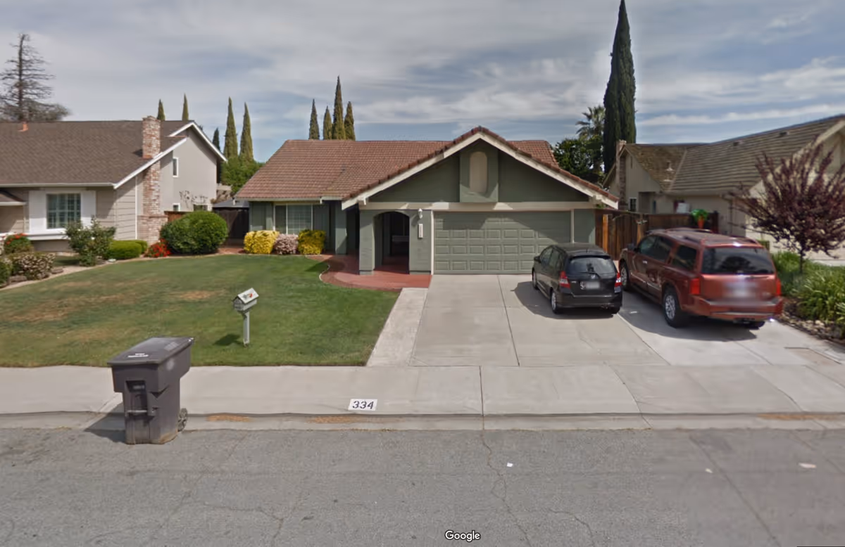 Front view of a suburban house with a two-car driveway and manicured lawn.