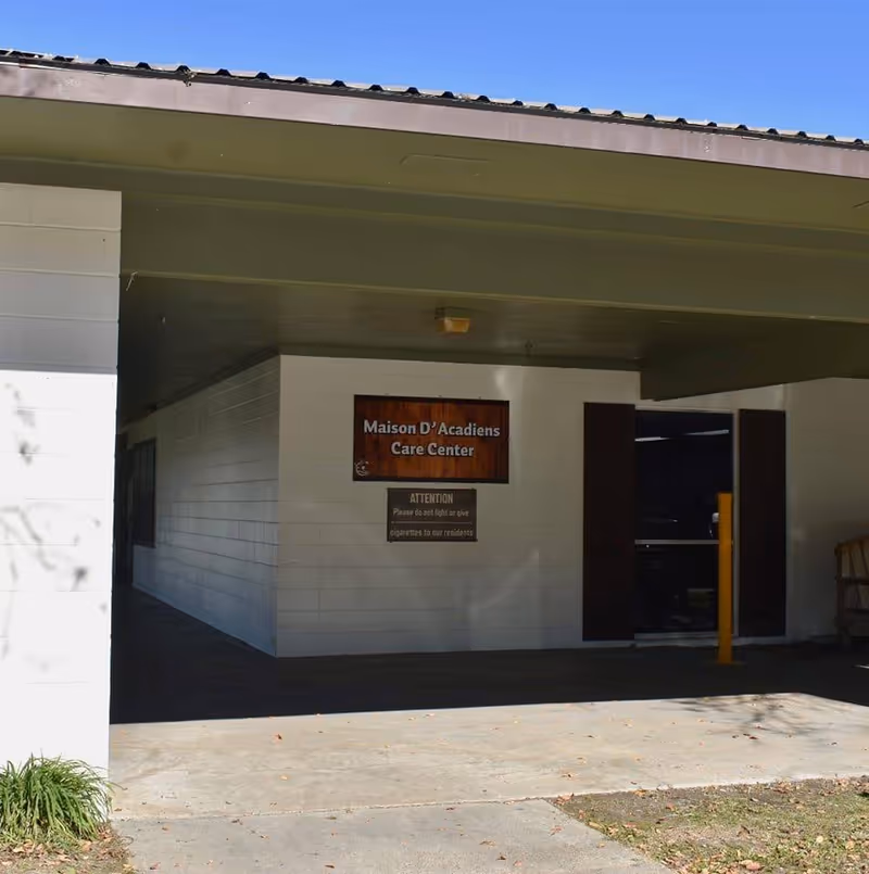 Exterior view of a white care center entrance with a wall sign.
