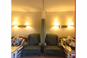 Two blue patterned armchairs sit in a warmly lit living room corner.