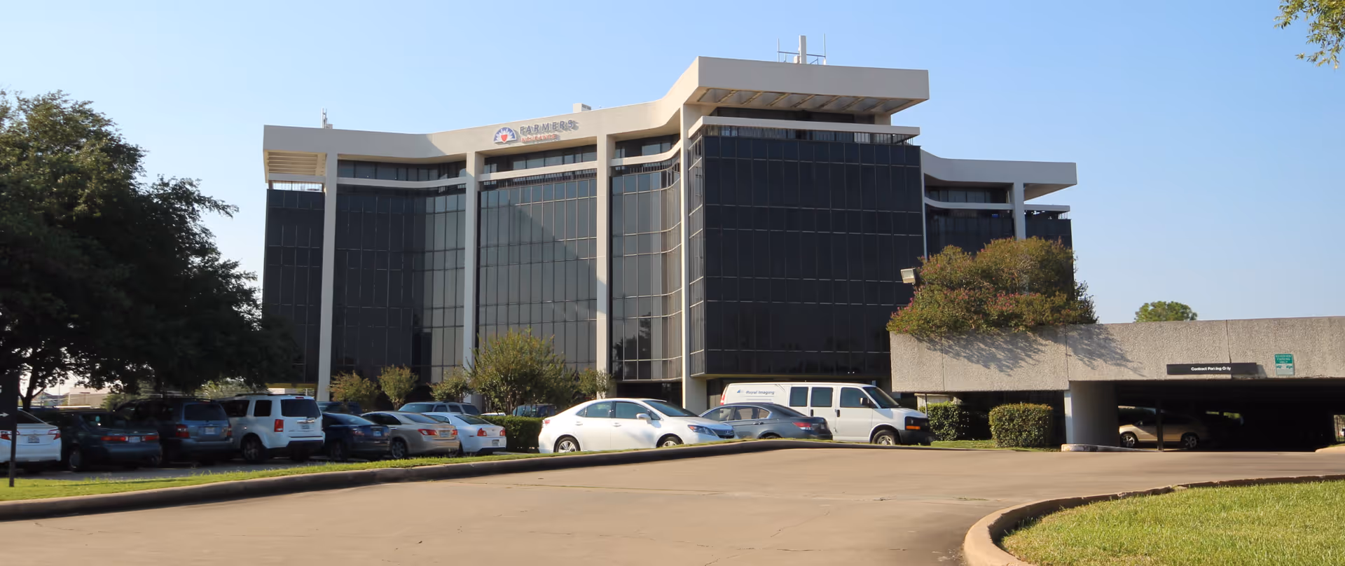 Exterior view of Alan Home Care Services building with glass facade and front parking lot.