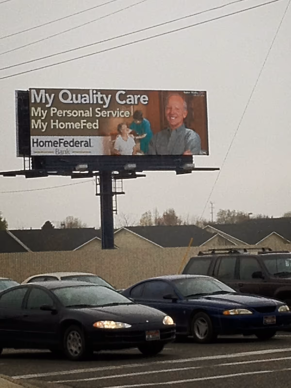 Outdoor billboard for MultiCare health services above a parking lot with cars.