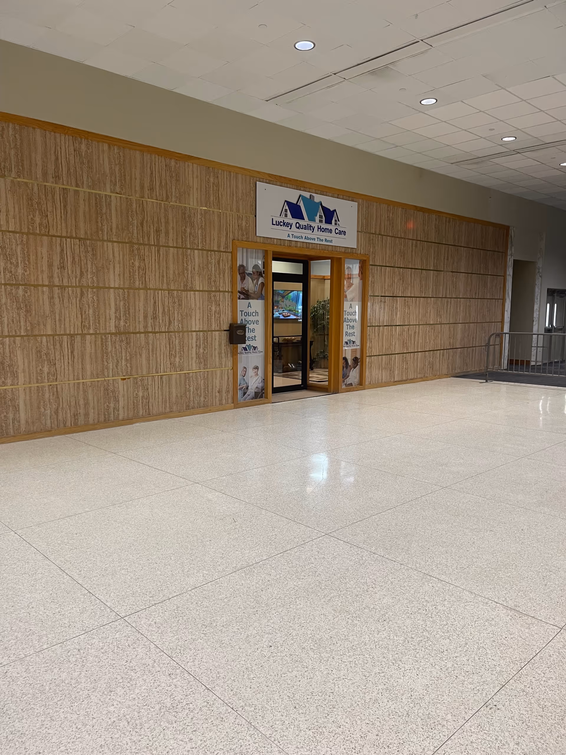 Indoor hallway with a Luckey Quality Home Care LLC entrance and glass doors.