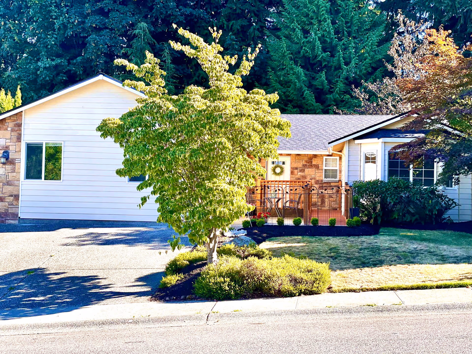 Single-story building exterior with white siding, stone accents, and a small front porch.