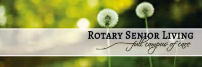 A Rotary Senior Living sign across a blurred green outdoor background.