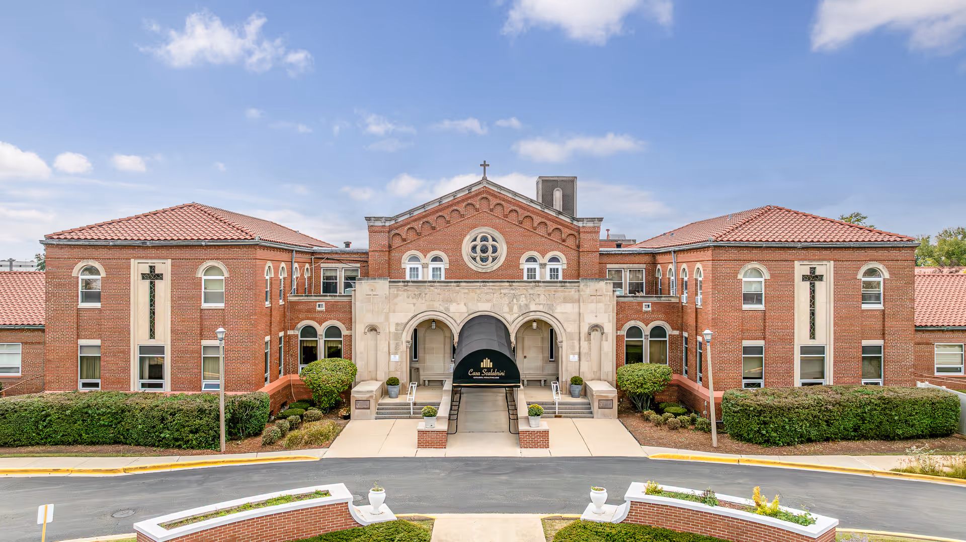 Citadel at Casa Scalabrini senior living facility with brick arches and a grand central entrance.