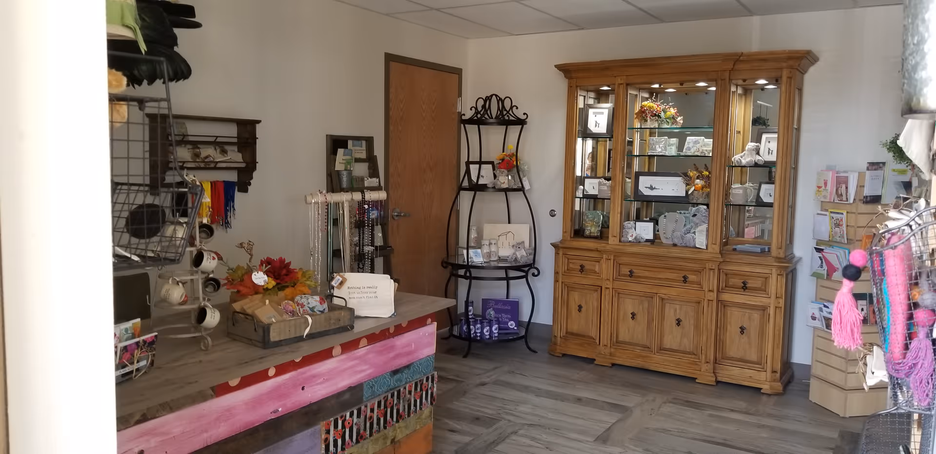 Gift shop area inside a senior living center with a large wooden display cabinet.