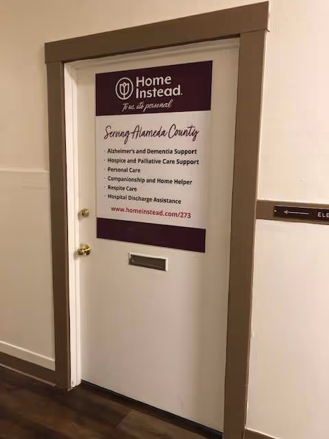 Interior hallway with a door displaying Home Instead Home Care Services signage.