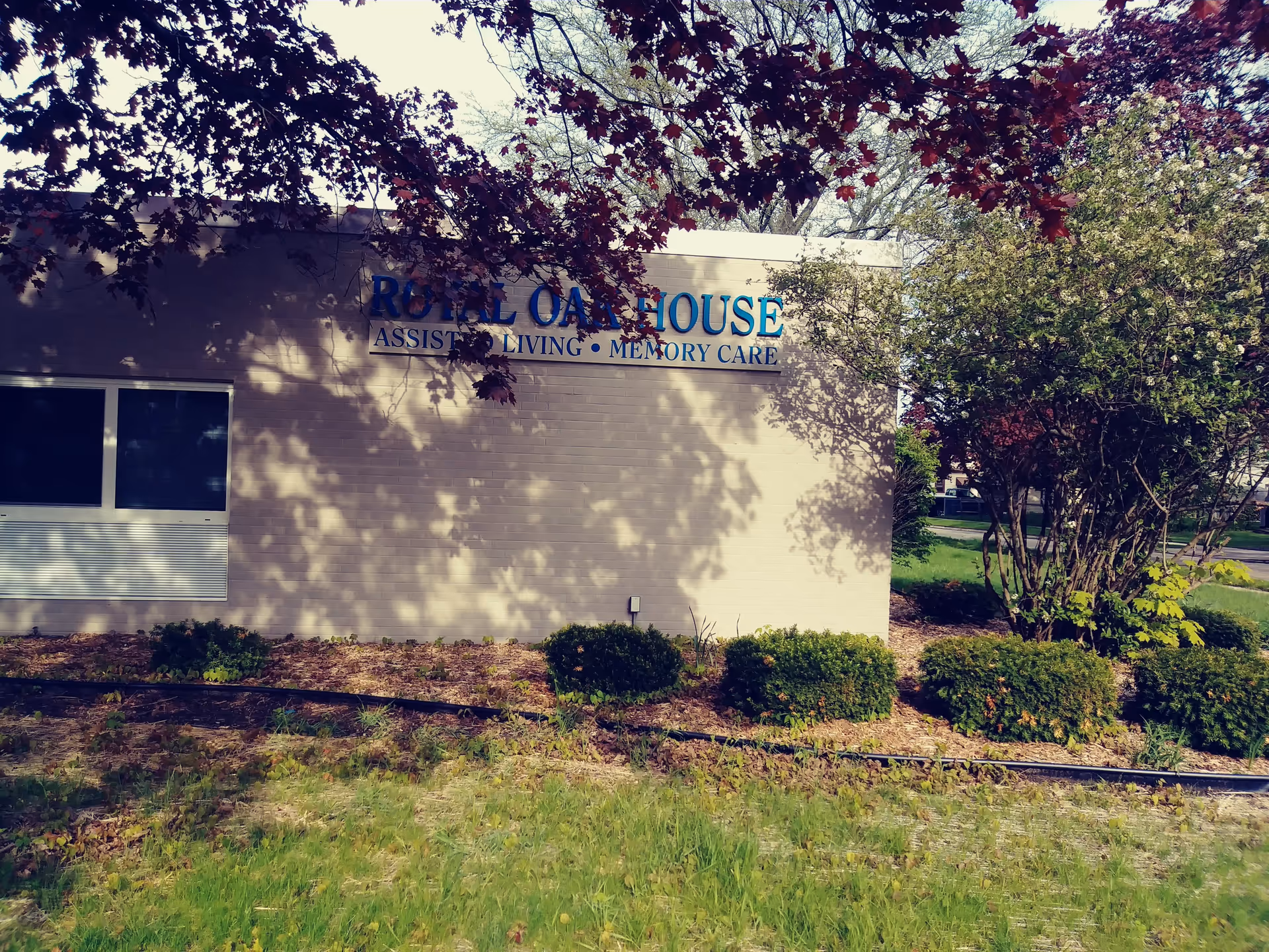 Exterior view of Royal Oak House sign on building with landscaping