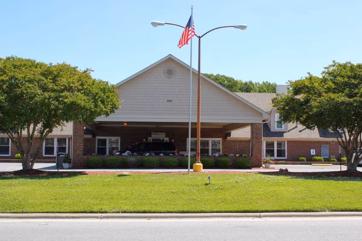 Front view of River Trace Nursing and Rehabilitation Center with flag and entrance.