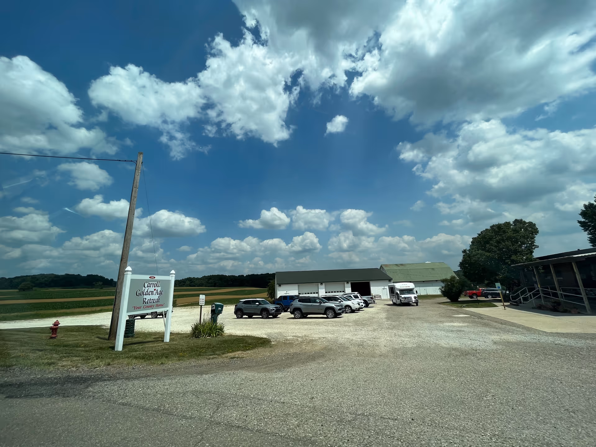 Exterior view of Carroll Golden Age Retreat with cars in a gravel parking lot