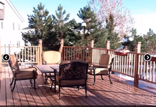 Outdoor wooden deck at Castle Rock Assisted Living III with seating and railing.