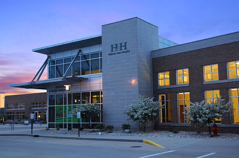 Exterior view of Hillsboro Health hospital building with glass entrance and signage.