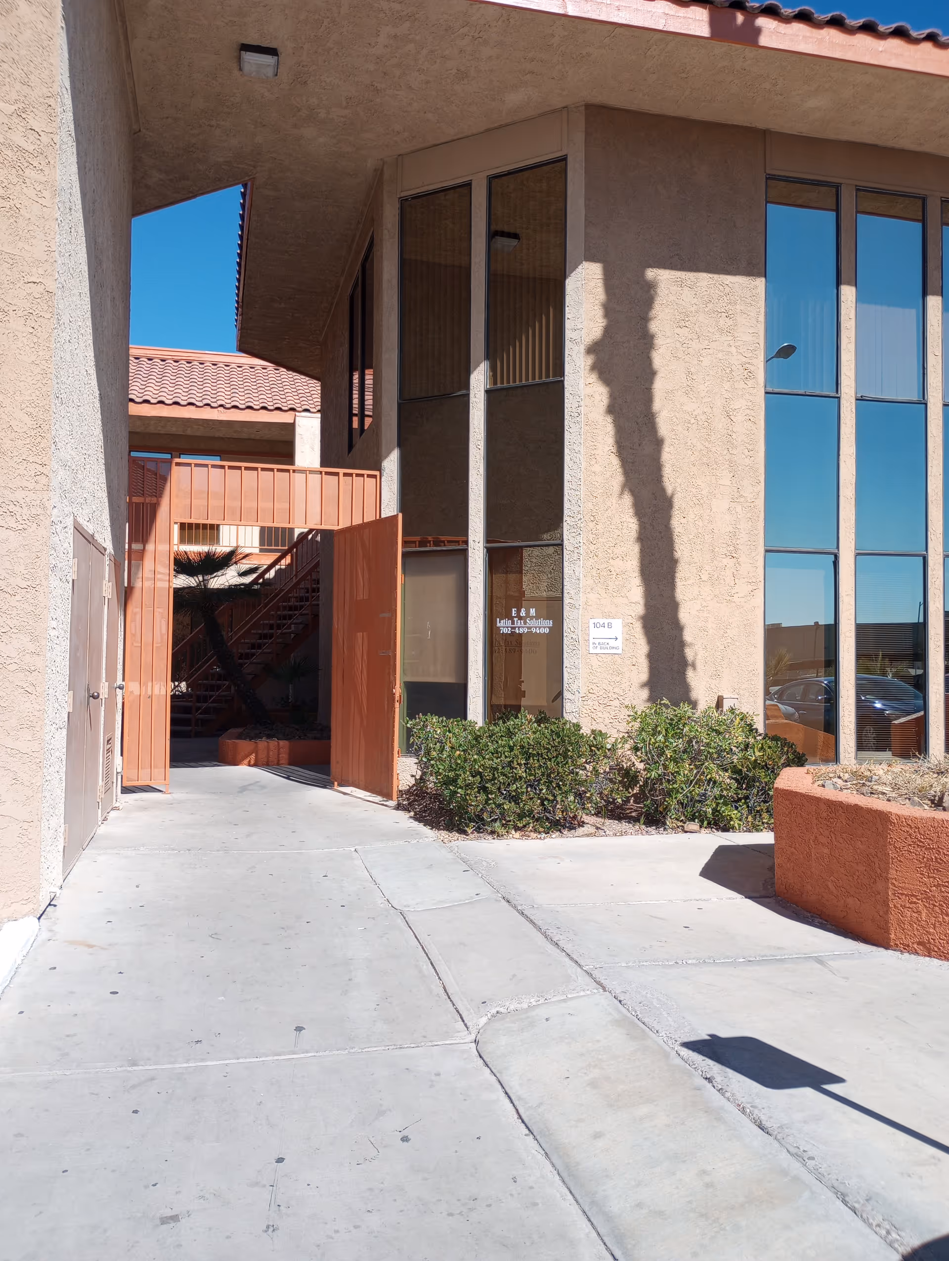 Exterior view of a senior living facility entrance with large windows and orange gate