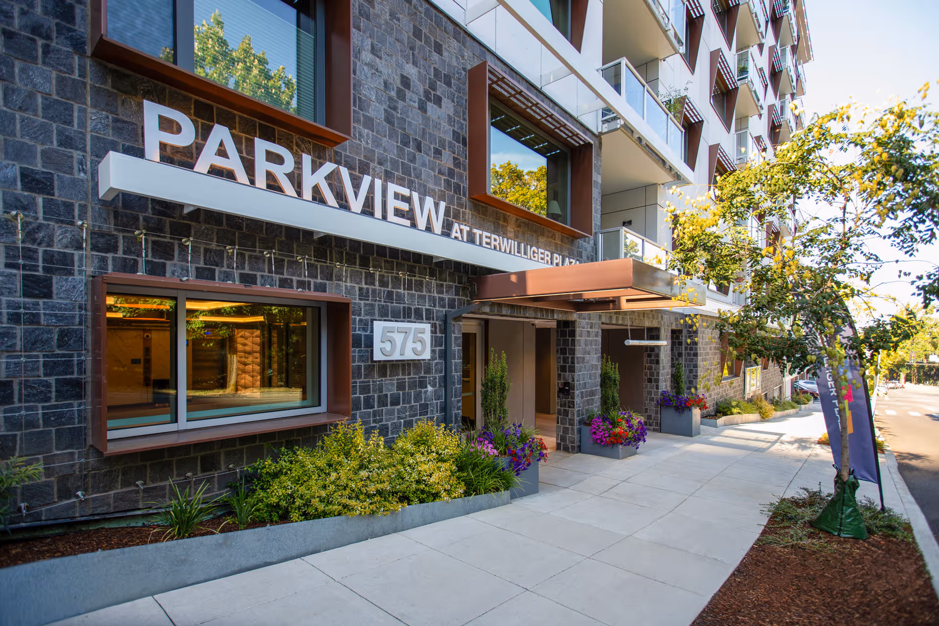 Exterior view of Parkview at Terwilliger Plaza entrance with landscaped sidewalk.
