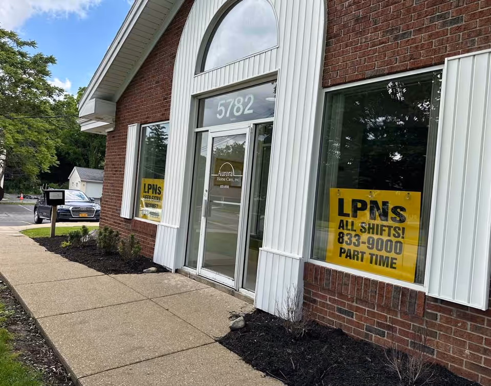 Brick building exterior with glass entrance and large yellow LPNS sign.