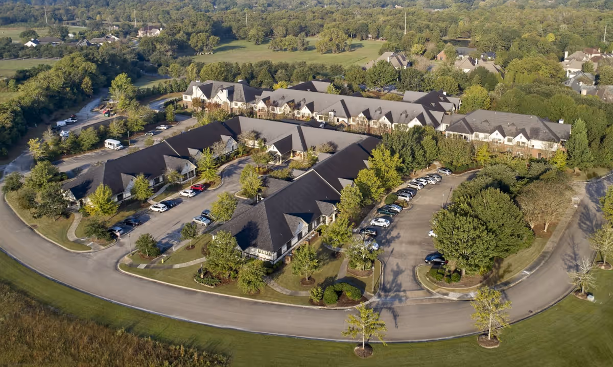 Aerial view of Oak Grove Inn senior living campus with L-shaped buildings and parking.
