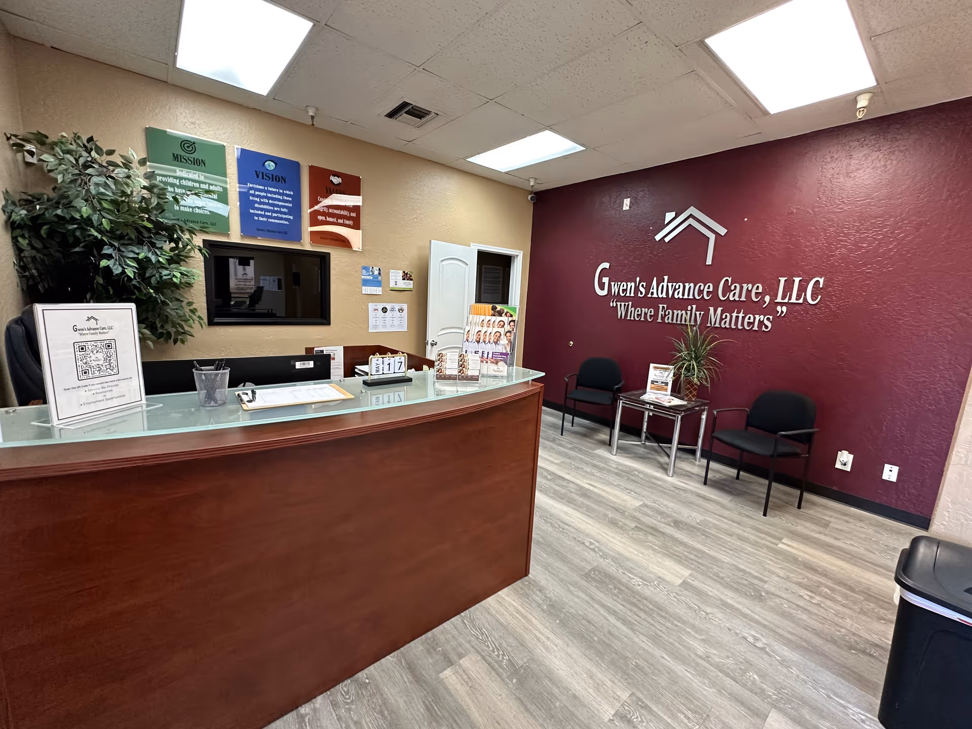 Reception area of Gwen's Advance Care with burgundy wall and seating.
