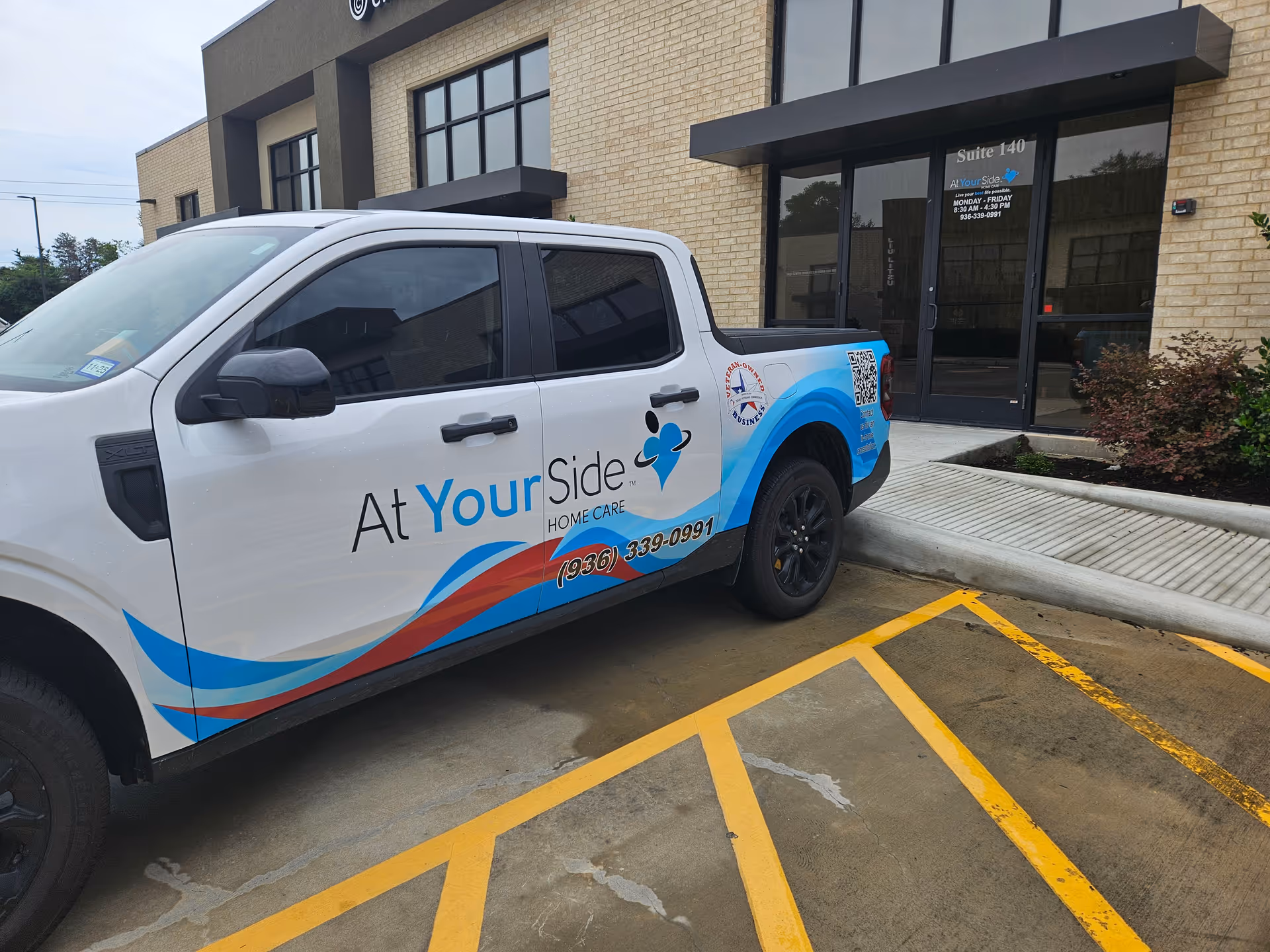 White At Your Side Home Care truck parked in front of Huntsville, TX facility entrance.