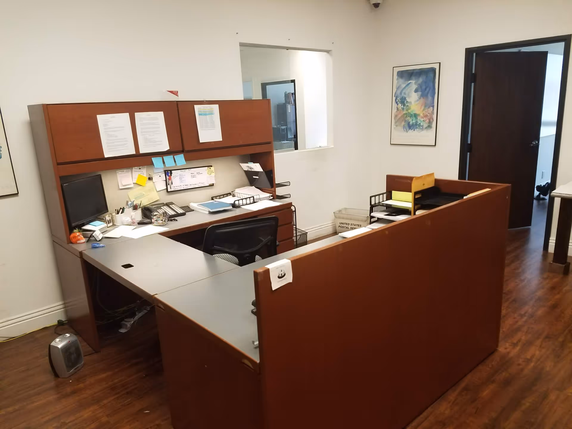 Interior reception area with desk, computers, and paperwork in a senior living facility.