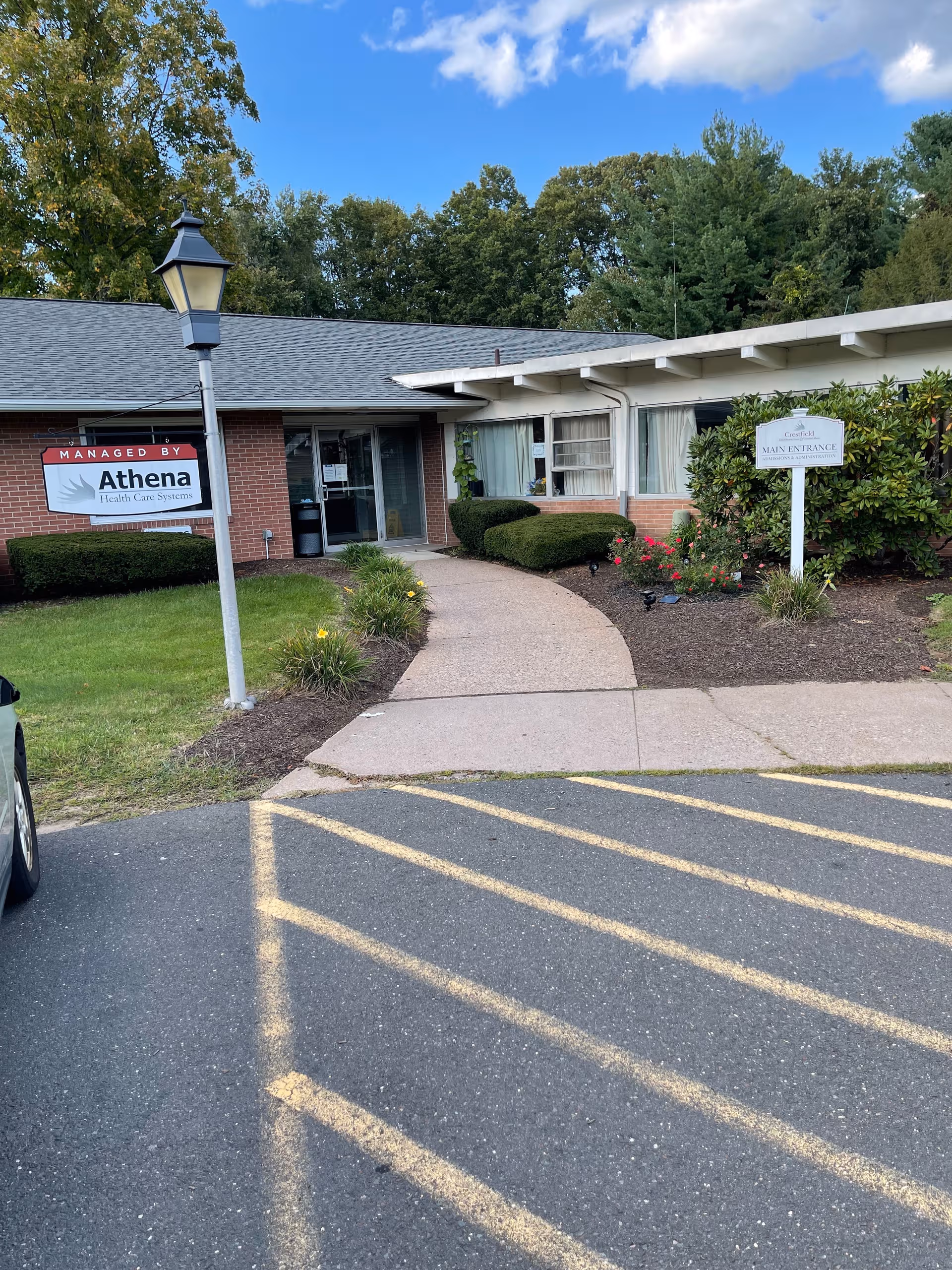 Exterior view of Crestfield Rehabilitation Center entrance with curved walkway and landscaping.