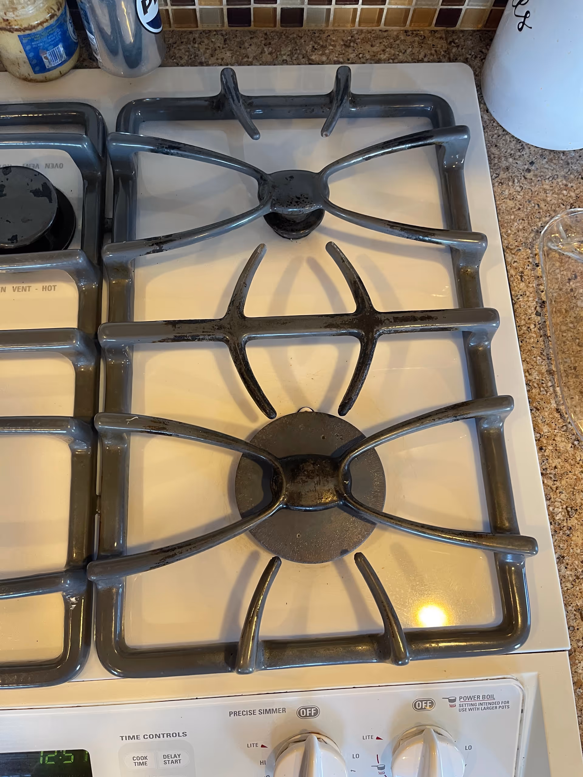 Top-down view of a gas stove with burners and surrounding countertop in a kitchen