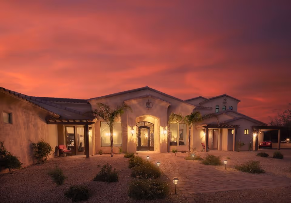 Sunset-lit exterior of Abellavida Memory Care facility with palm trees and entry courtyard.