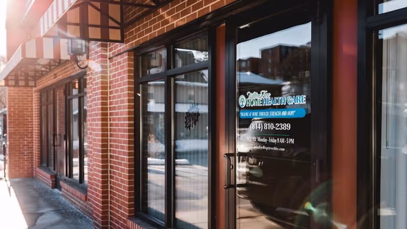 Brick building exterior with glass door and Willow Tree Home Health Care sign.
